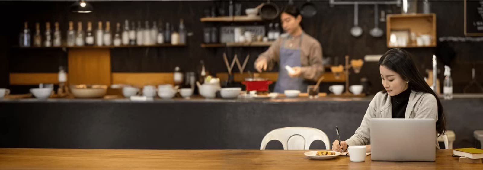 Restaurant owner working on a laptop at a cafe counter